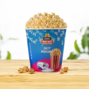 Salty De Home Mart popcorn cup on a wooden table