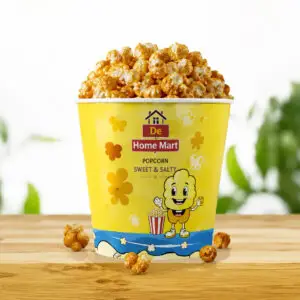 Sweet and Salty De Home Mart popcorn cup on a wooden table